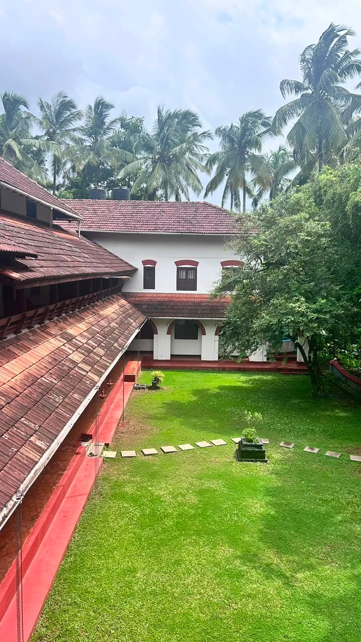 The tiled roofline of The Heritage 1866 seen from an upper verandah, with coconut palms beyond